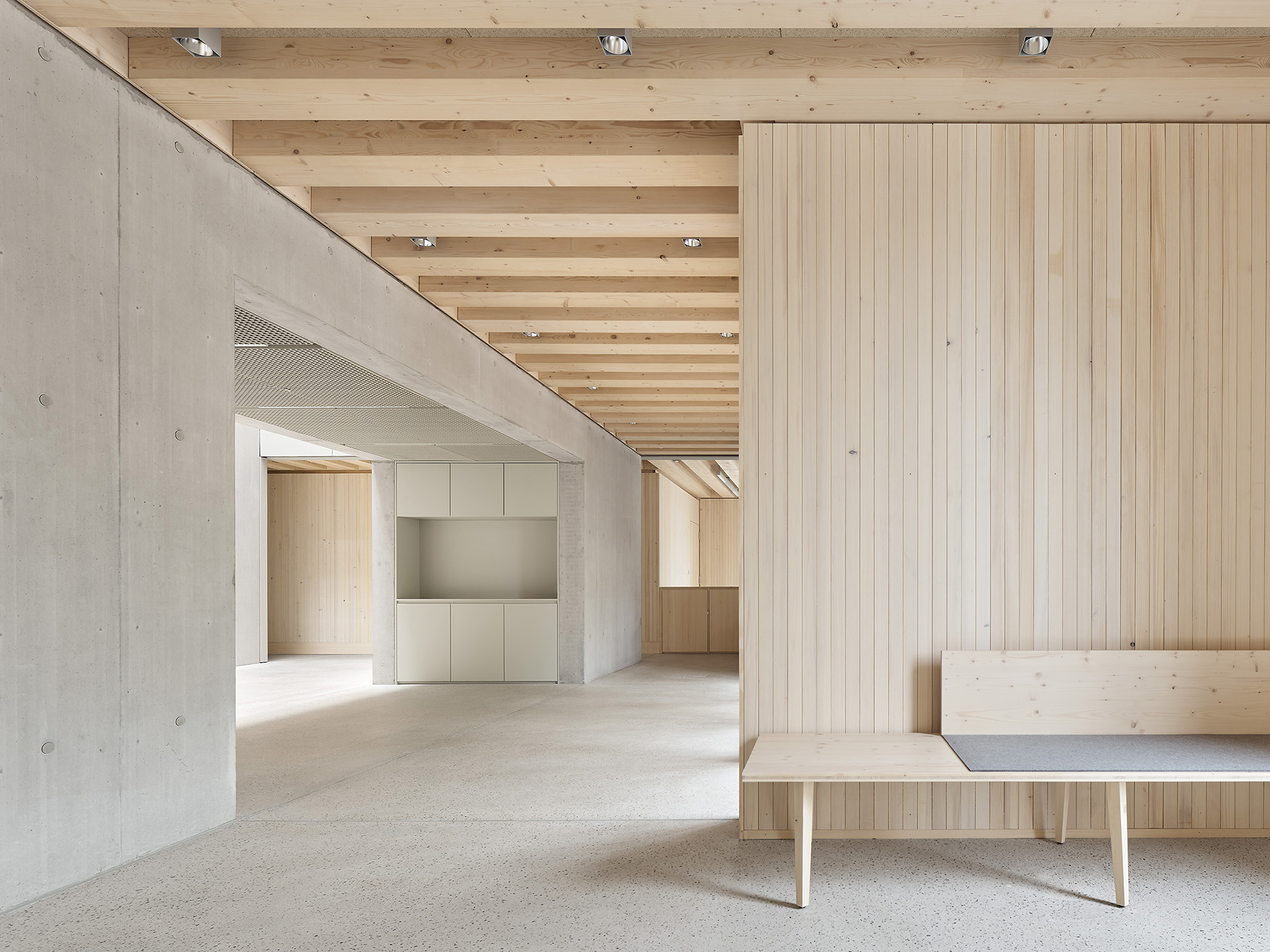 Modernes, minimalistisches Innenraumdesign mit Holzverkleidung, Betonwänden und einer Holzbank